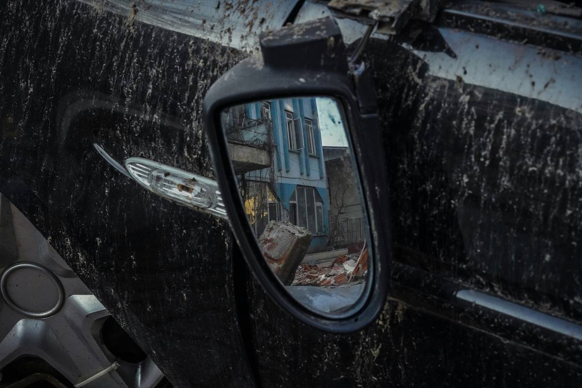 Close-up of a wrecked car's crumpled side mirror