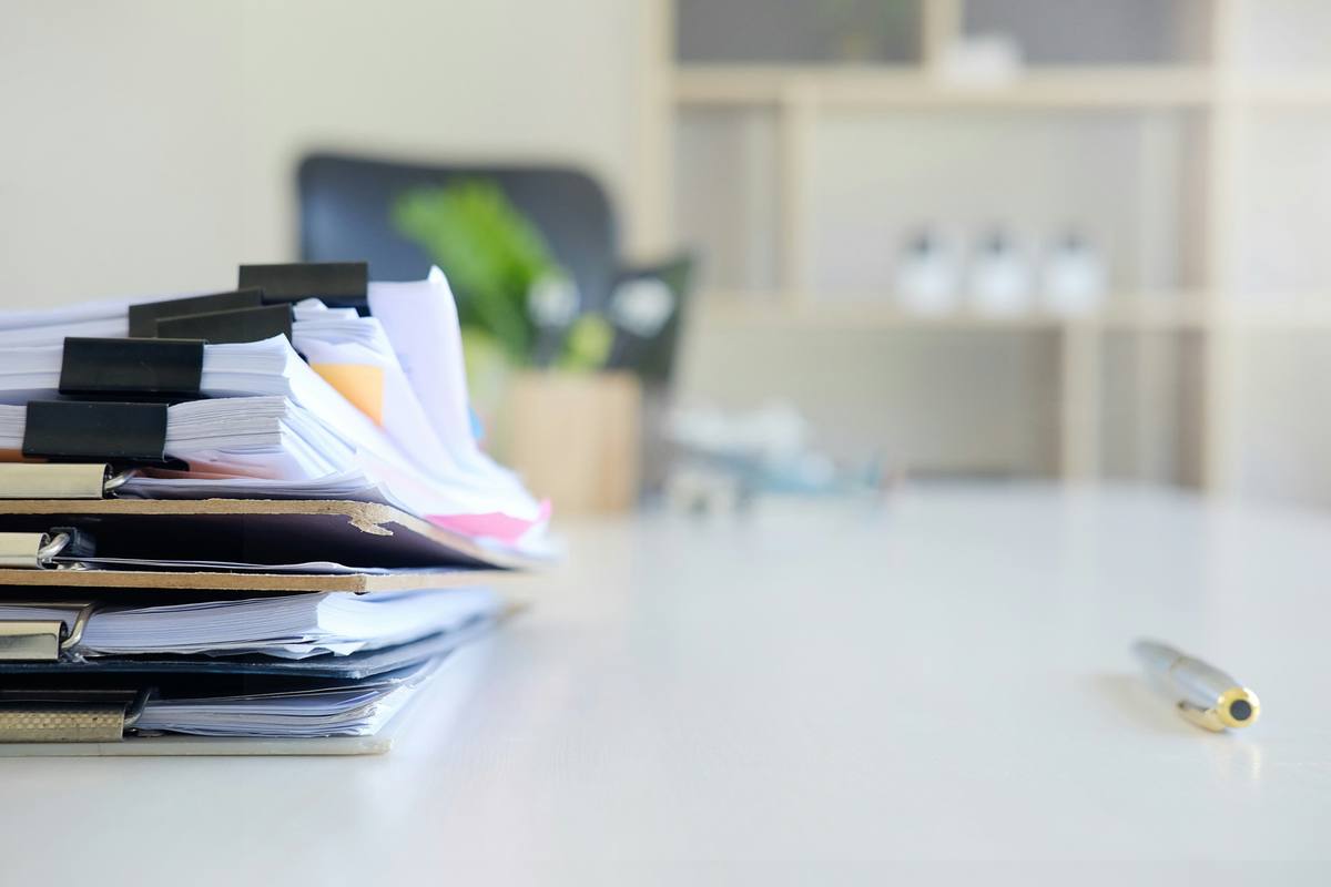 Stack of clipped insurance claim documents on a desk