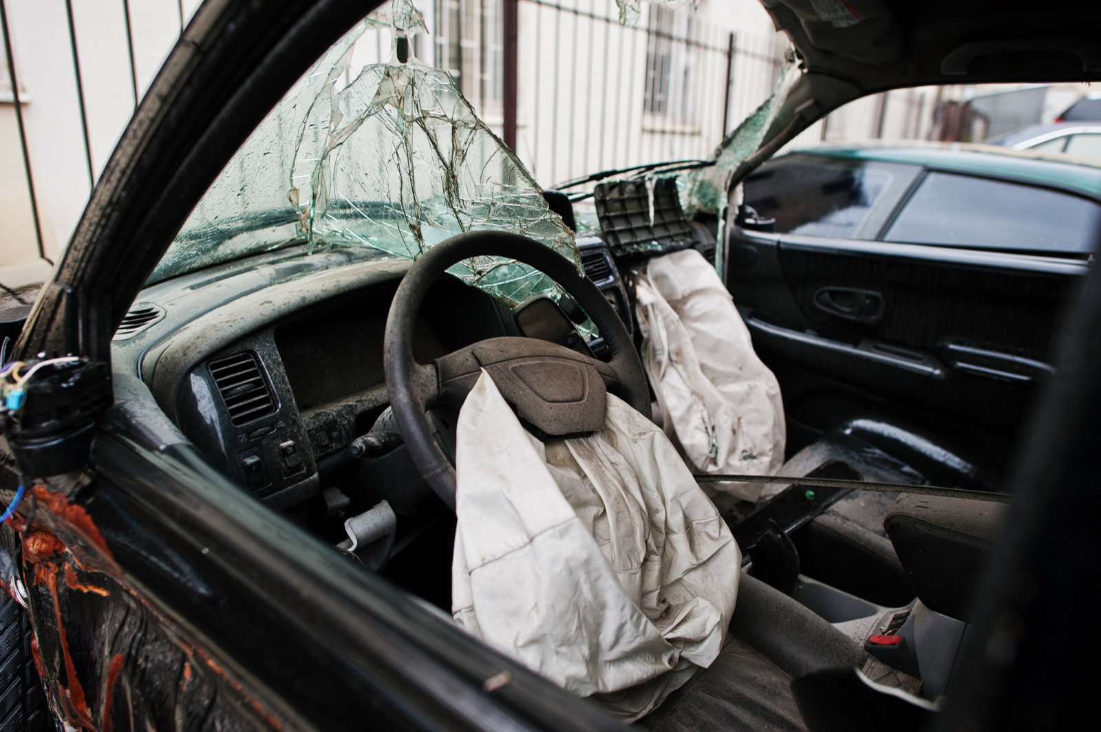Deployed airbags and shattered windshield inside a crashed car
