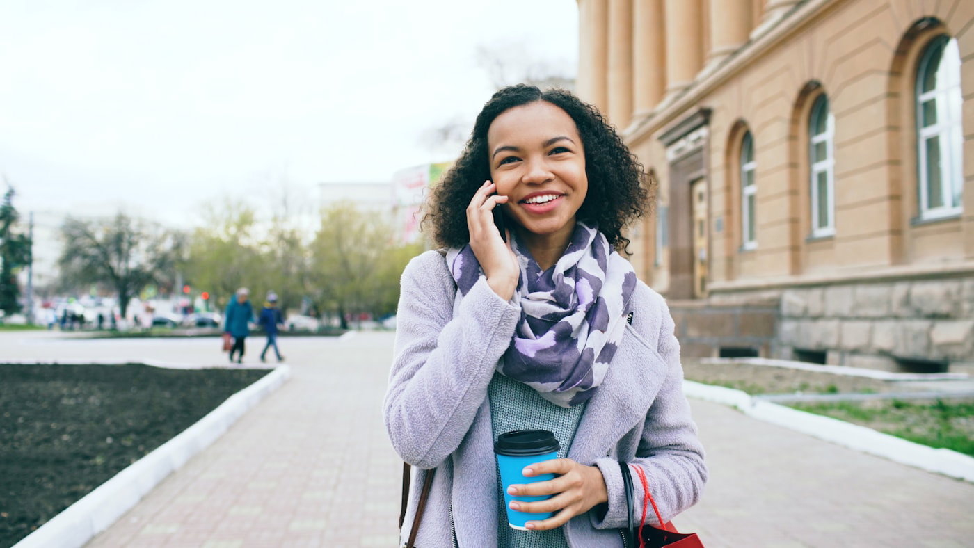 Woman smiling on a phone call outdoors