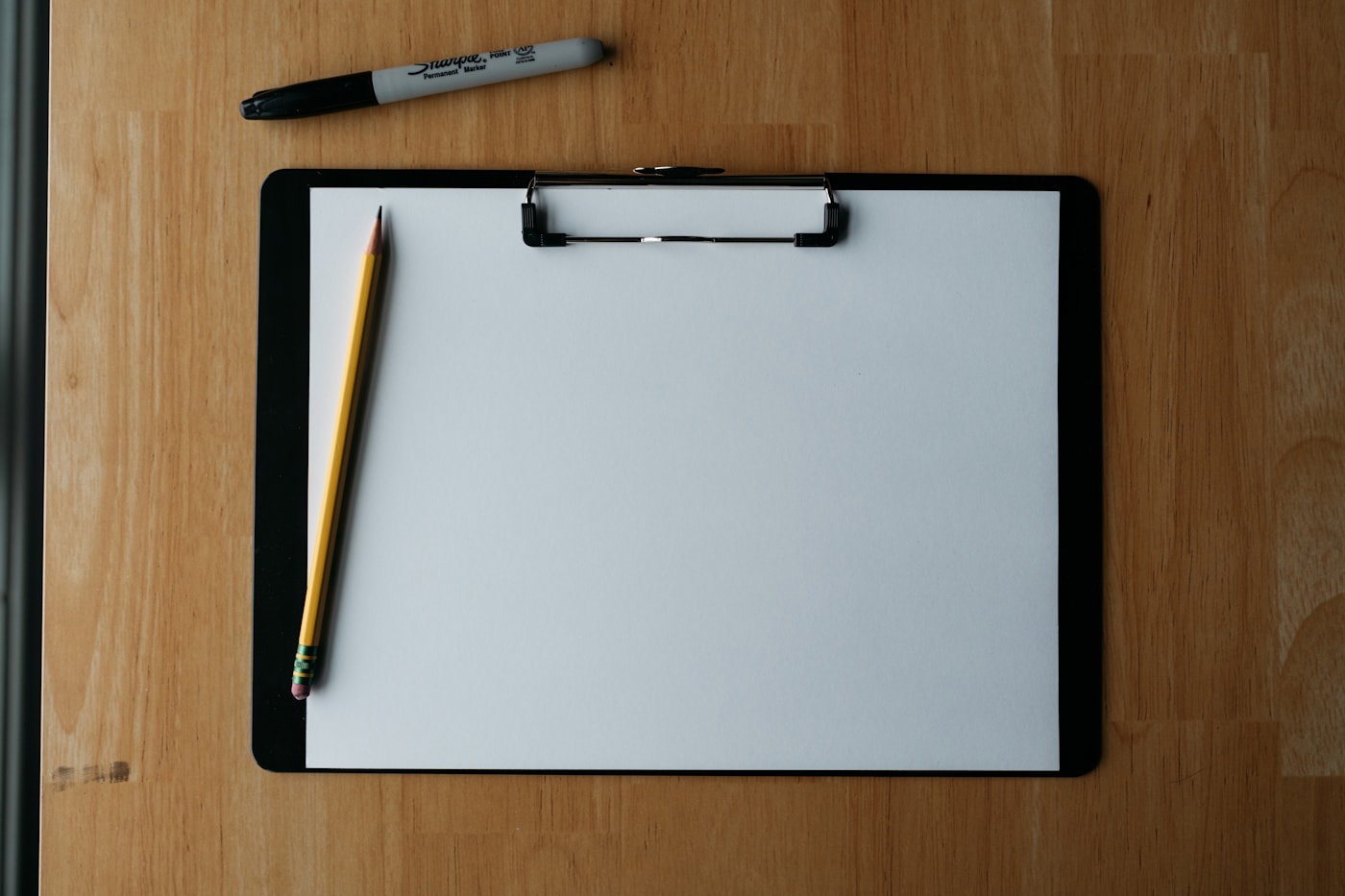 Clipboard with a blank claim form, pen, and pencil on a desk
